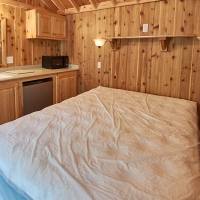 inside of cabin with bed and kitchenette area