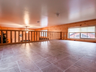 Loft with tile floor and railing in cabin
