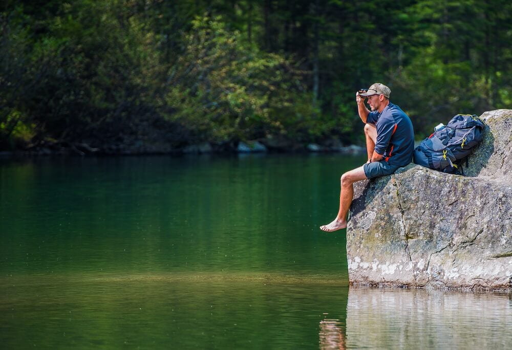 Hiker sitting overlooking lake