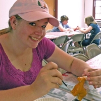 girl painting a ceramic horse