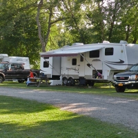 white camper parked at campiste with truck