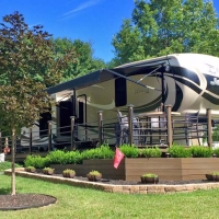 Camper with porch and greenery and flags